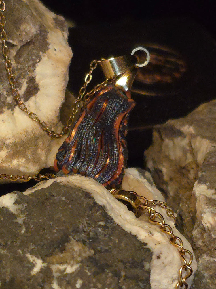 Raw uncut Ethiopian Welo opal pendant. Colour: green leading, red cutting in, blue at the edges, strong. Body: crystal clear. Resting on rough rock.